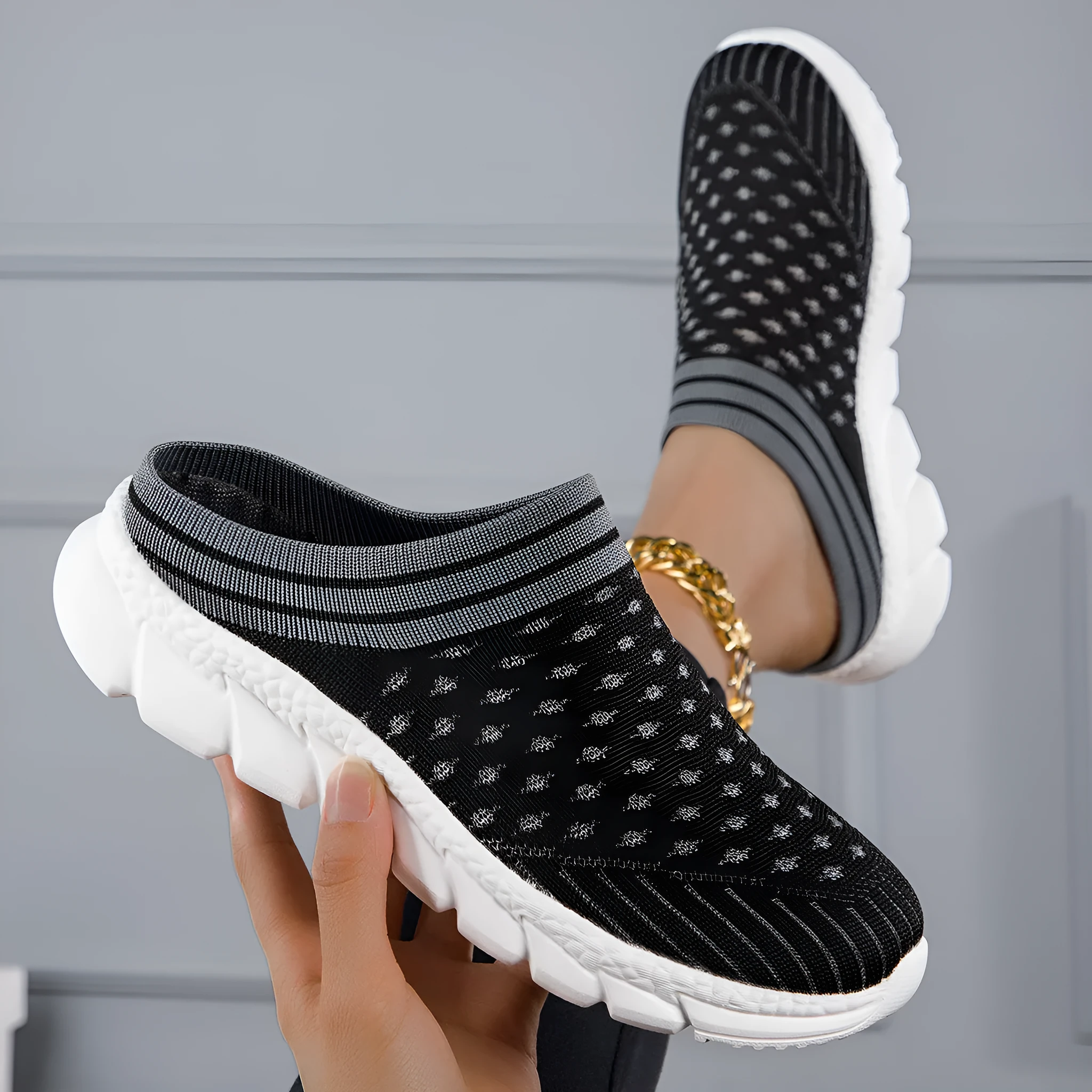Women's black striped Flyknit slipper shoes with hollowed-out design on a viscose sole.