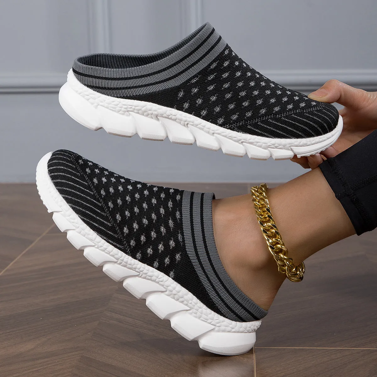 Women's black striped Flyknit slipper shoes with hollowed-out design on a viscose sole.