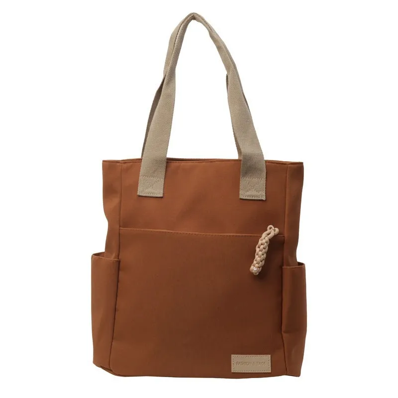Women's large canvas satchel in beige with shoulder strap, horizontal square shape, and visible sewing thread details