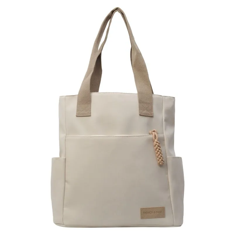 Women's large canvas satchel in beige with shoulder strap, horizontal square shape, and visible sewing thread details