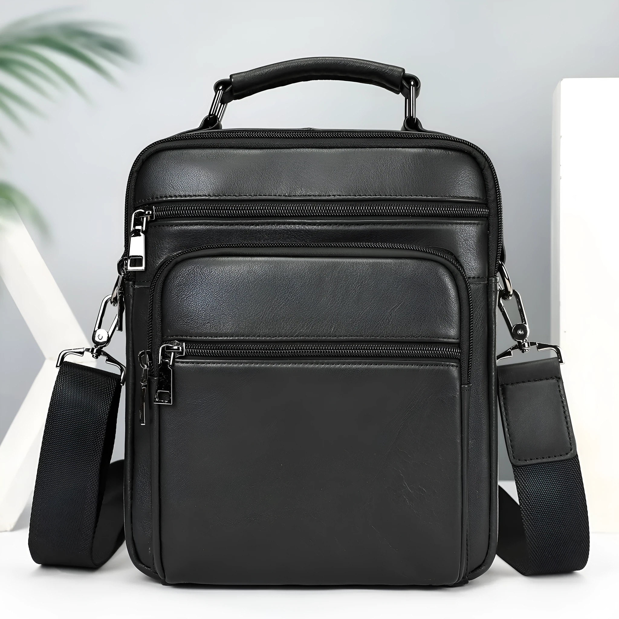 Men's genuine leather messenger bag in black with visible sewing line details and shoulder strap
