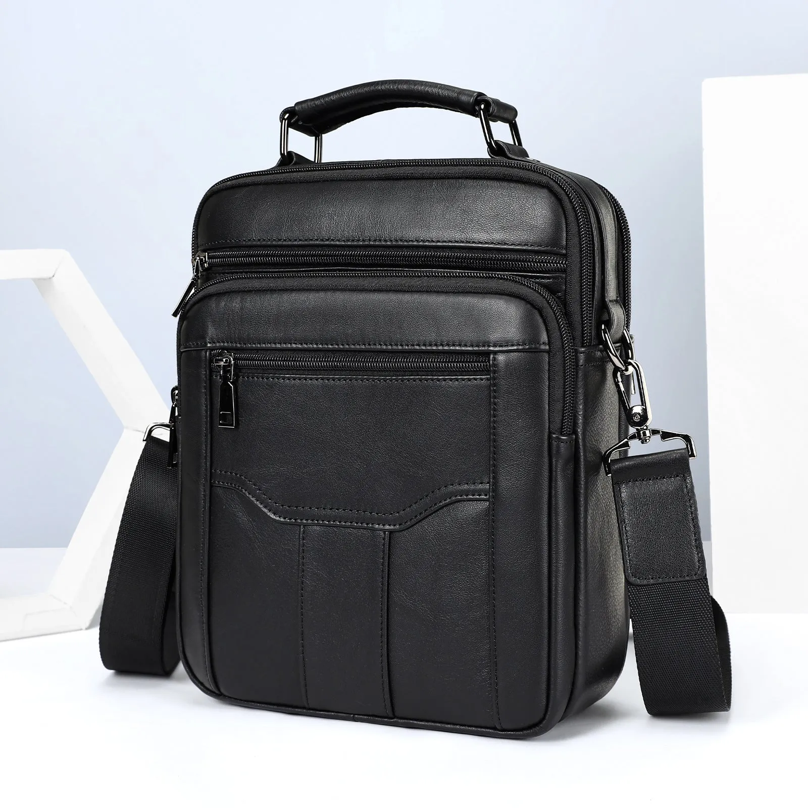 Men's genuine leather messenger bag in black with visible sewing line details and shoulder strap