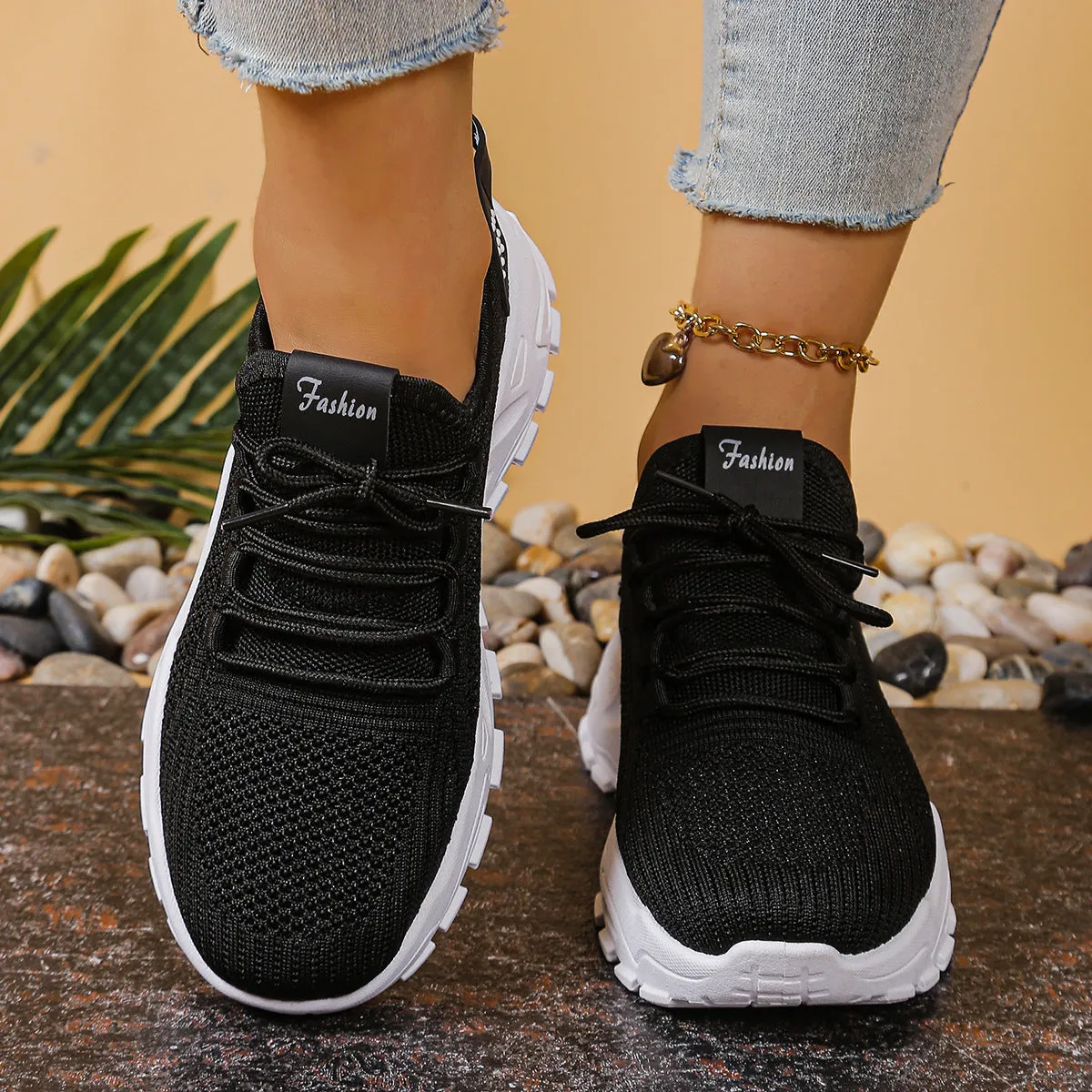 Women's low-top mesh sports shoes in a flyknit style with a round toe and front lace-up closure.