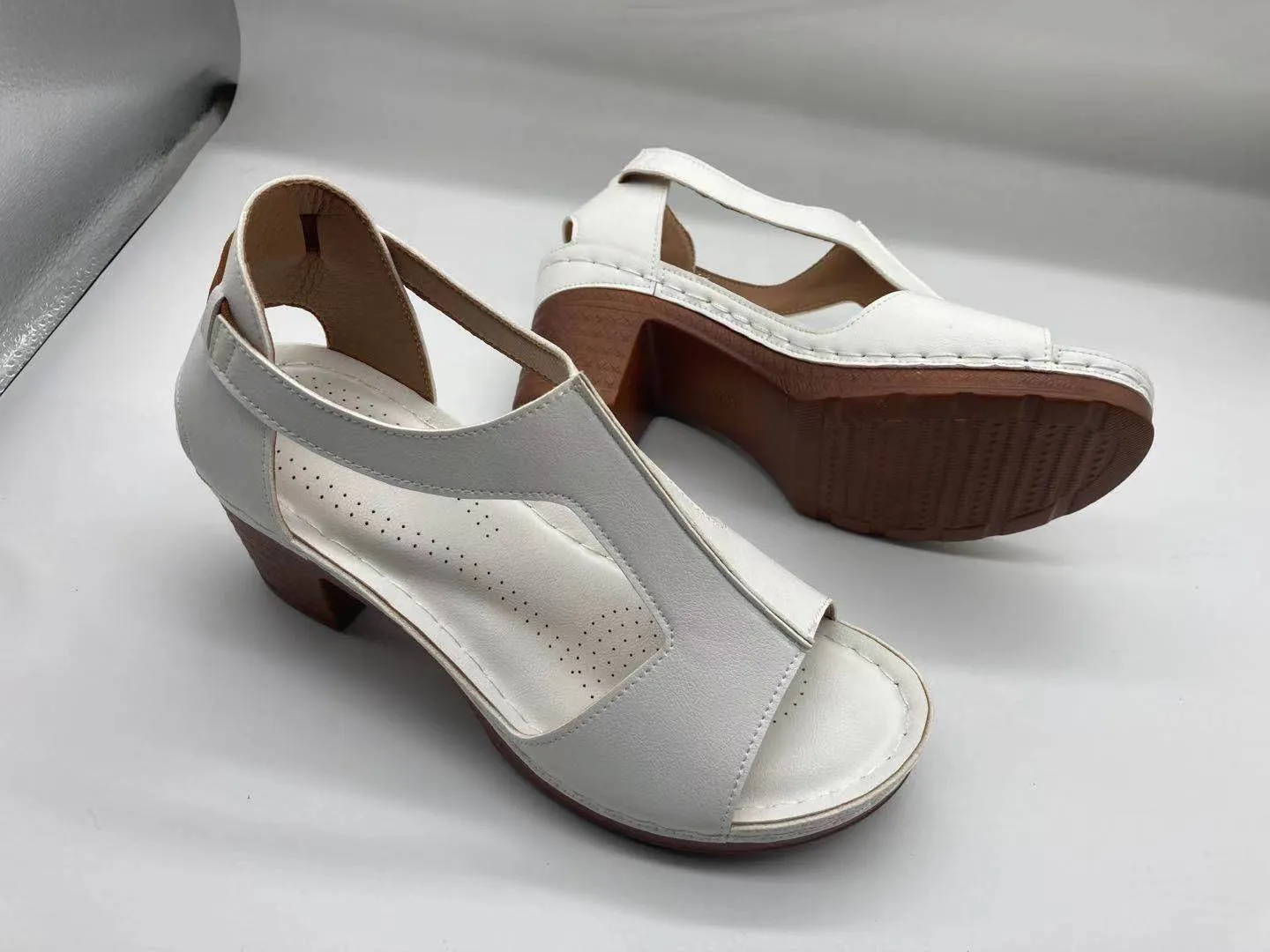 Womens beige Roman style wedge sandals with open peep toe and silver buckle strap on a low heel.