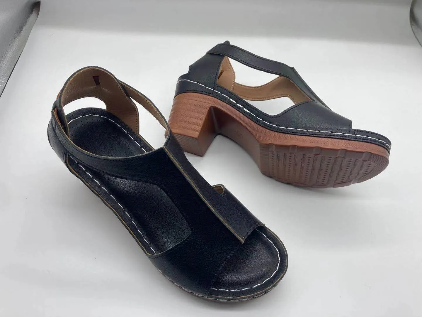Womens beige Roman style wedge sandals with open peep toe and silver buckle strap on a low heel.