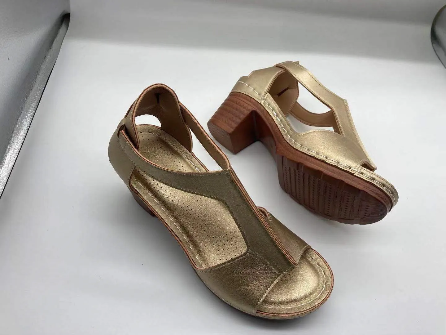 Womens beige Roman style wedge sandals with open peep toe and silver buckle strap on a low heel.