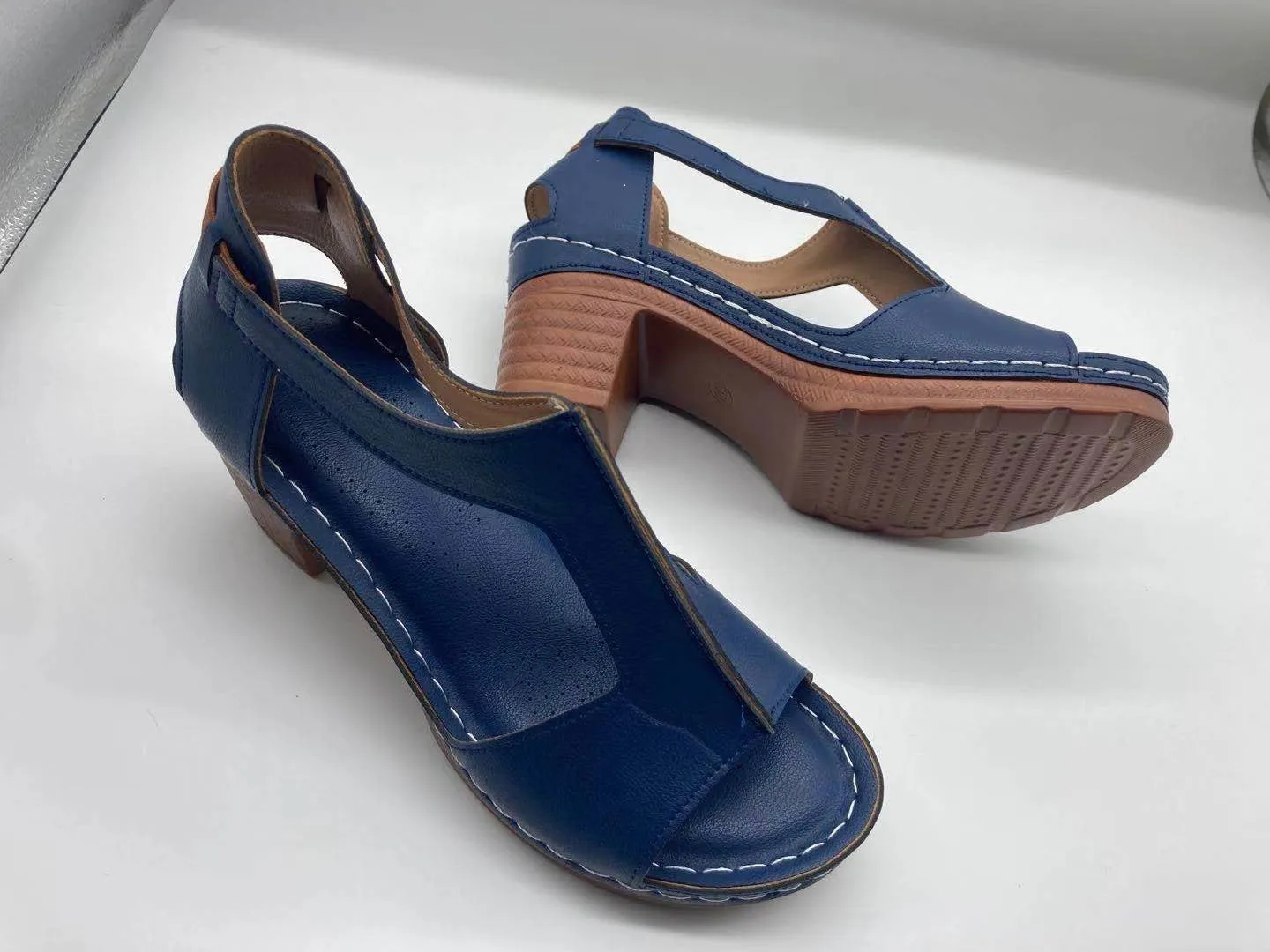 Womens beige Roman style wedge sandals with open peep toe and silver buckle strap on a low heel.