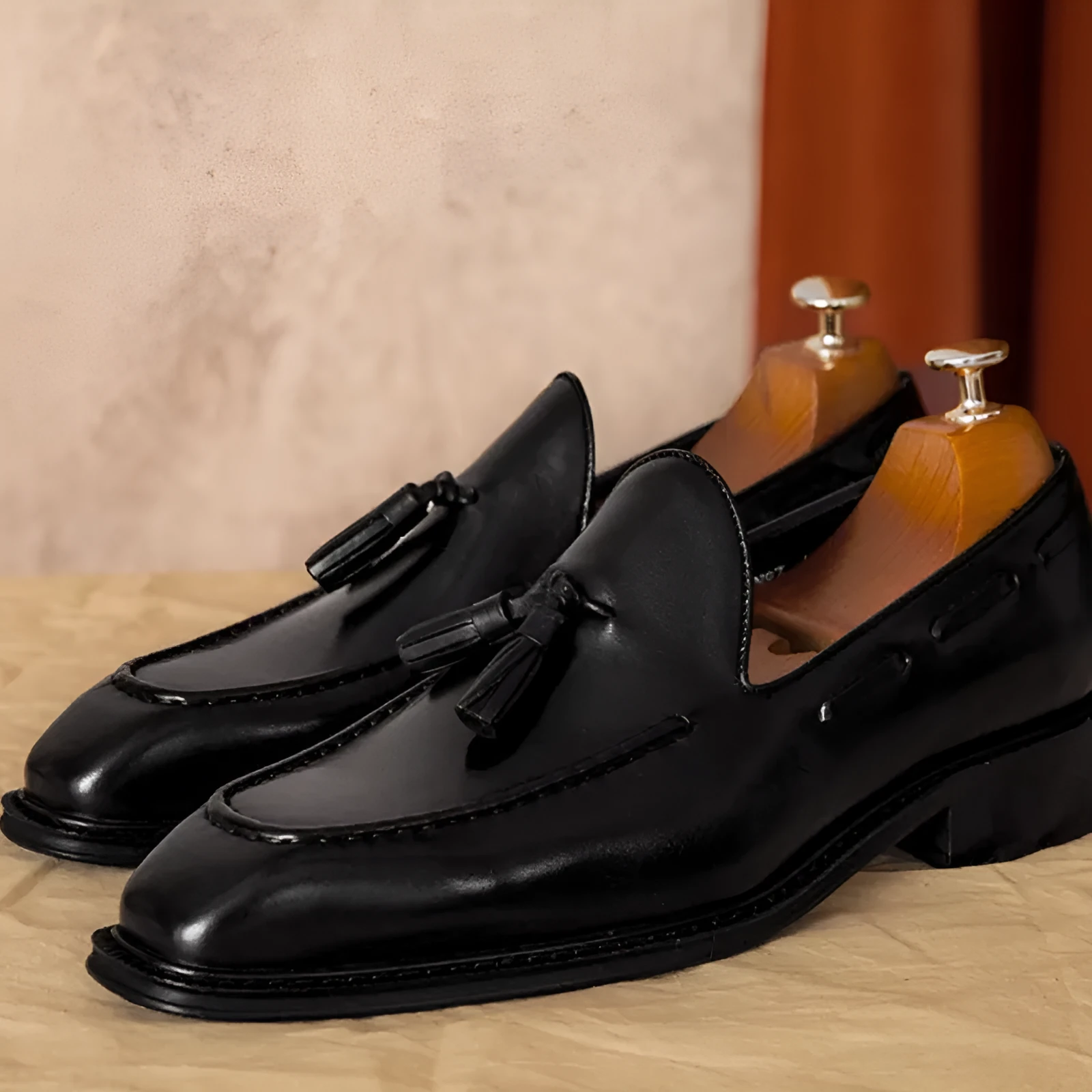 Men's black and brown genuine leather slip-on loafers with a fringed detail and rubber sole.