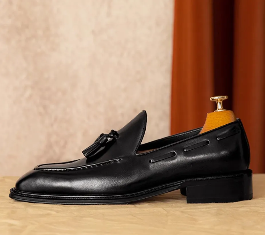 Men's black and brown genuine leather slip-on loafers with a fringed detail and rubber sole.