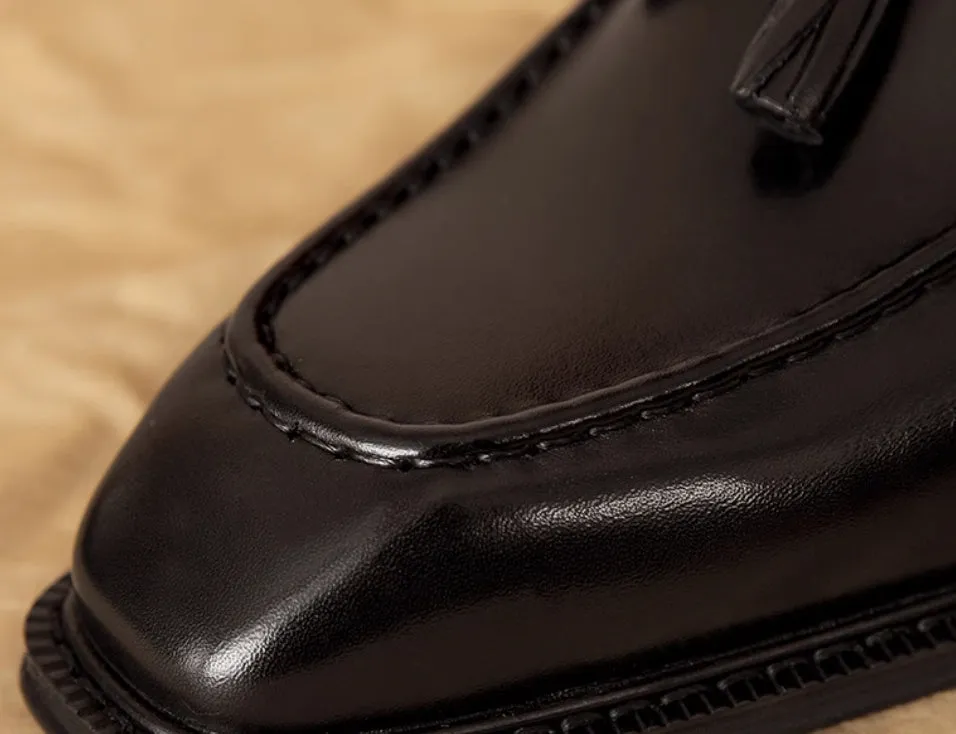 Men's black and brown genuine leather slip-on loafers with a fringed detail and rubber sole.