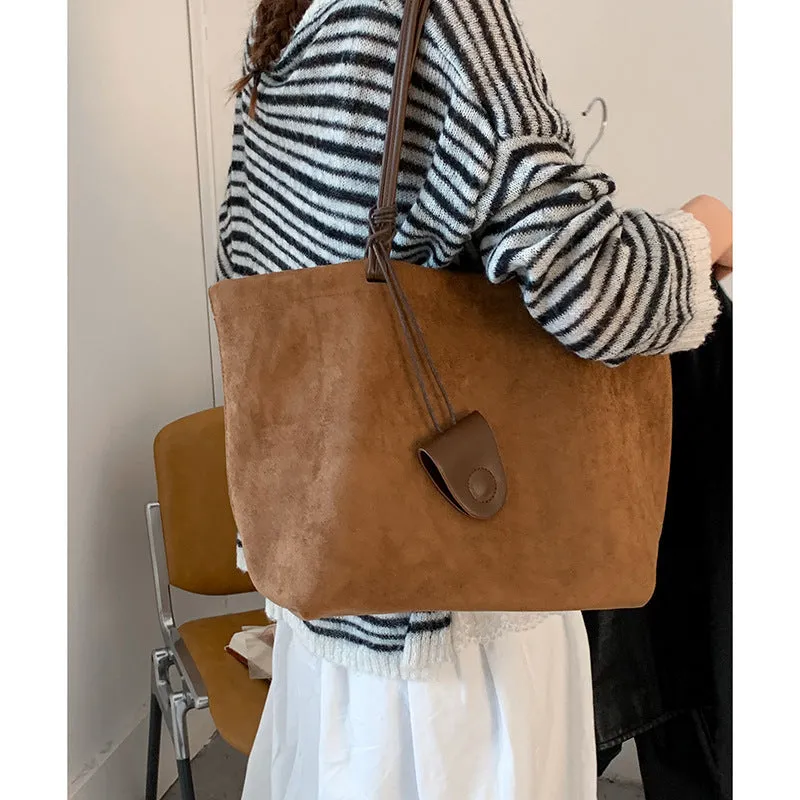 Brown suede shoulder bag with double straps and sewing line detail on a white background