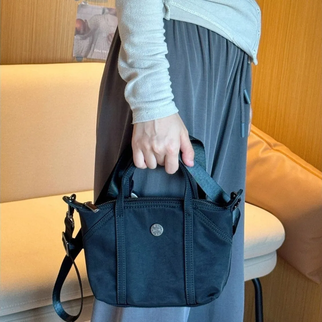 Casual lightweight nylon crossbody bag in dumpling shape, available colours black brown orange pink yellow, with pendant