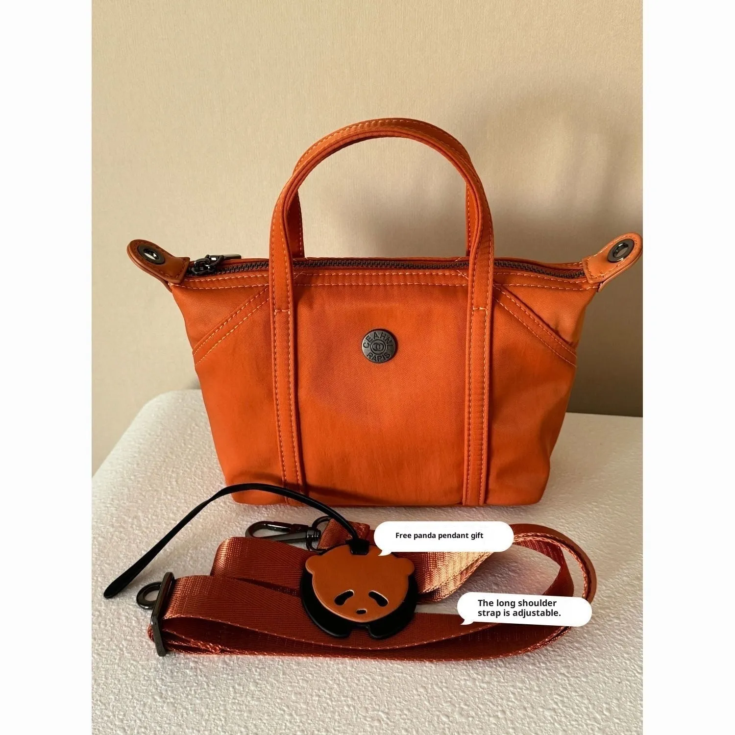 Casual lightweight nylon crossbody bag in dumpling shape, available colours black brown orange pink yellow, with pendant