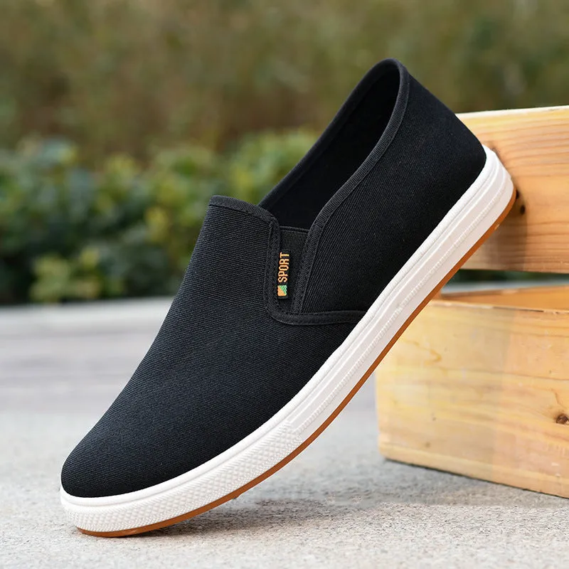 Men's low-top black canvas slip-on shoes with round toe and shallow mouth on a composite sole.