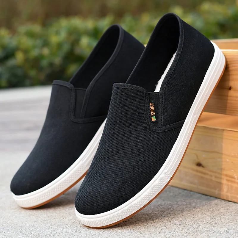 Men's low-top black canvas slip-on shoes with round toe and shallow mouth on a composite sole.