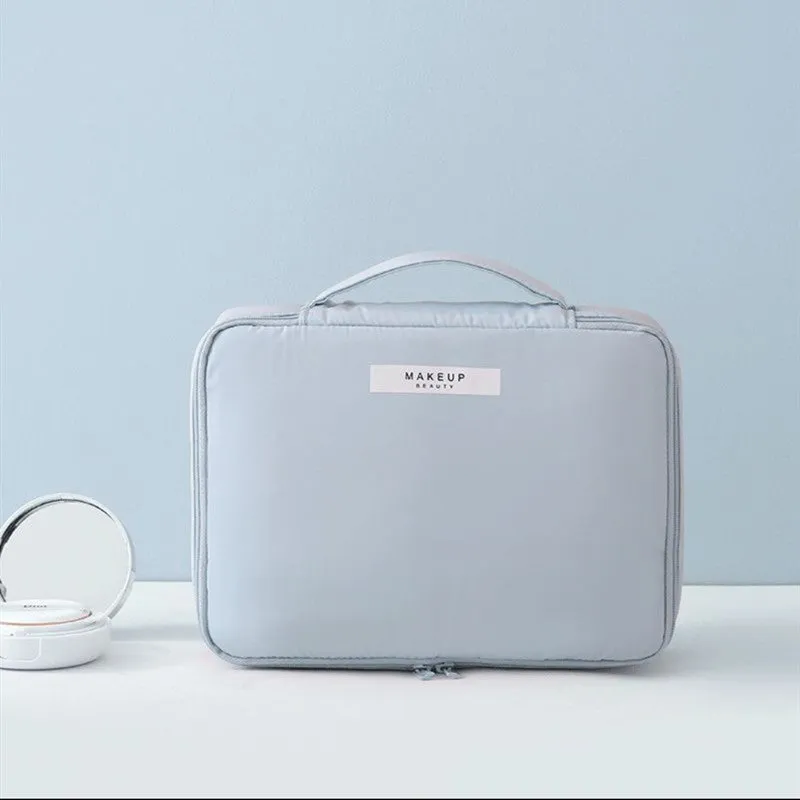 Nylon cube cosmetic bag in blue with sealed closure, available in large and small sizes for travel makeup storage