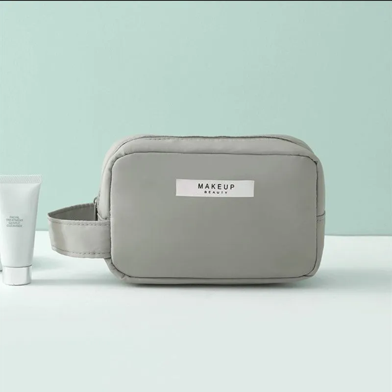 Nylon cube cosmetic bag in blue with sealed closure, available in large and small sizes for travel makeup storage