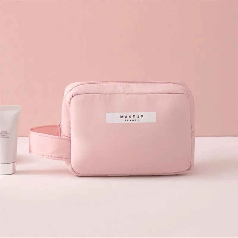 Nylon cube cosmetic bag in blue with sealed closure, available in large and small sizes for travel makeup storage