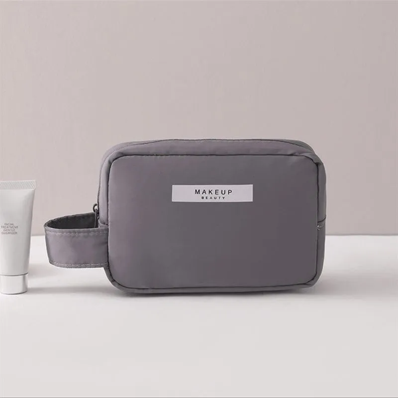 Nylon cube cosmetic bag in blue with sealed closure, available in large and small sizes for travel makeup storage