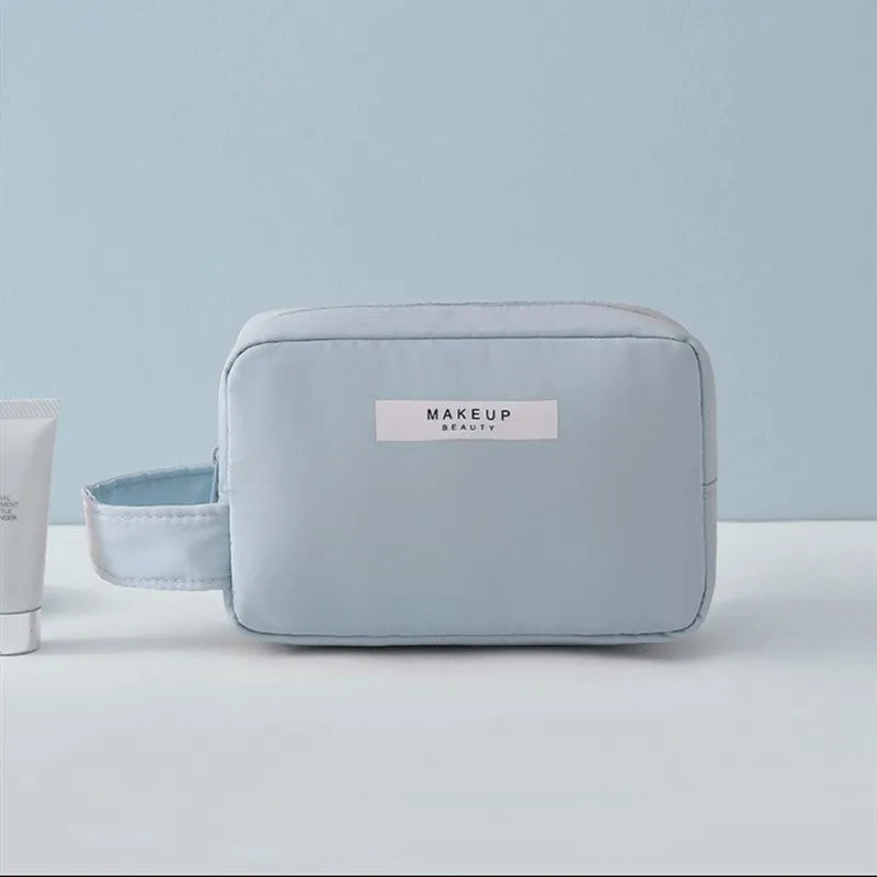 Nylon cube cosmetic bag in blue with sealed closure, available in large and small sizes for travel makeup storage