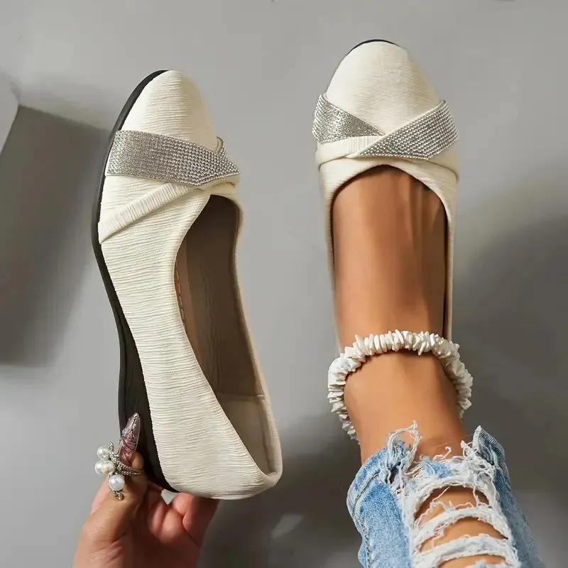 Women's black casual slip-on shoes with rhinestone details and a chunky heel on a white background.
