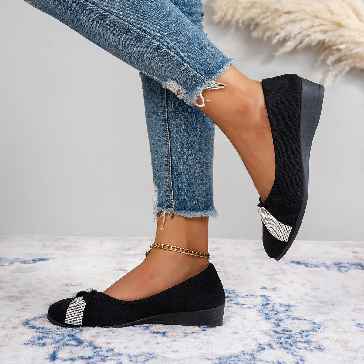 Women's black casual slip-on shoes with rhinestone details and a chunky heel on a white background.