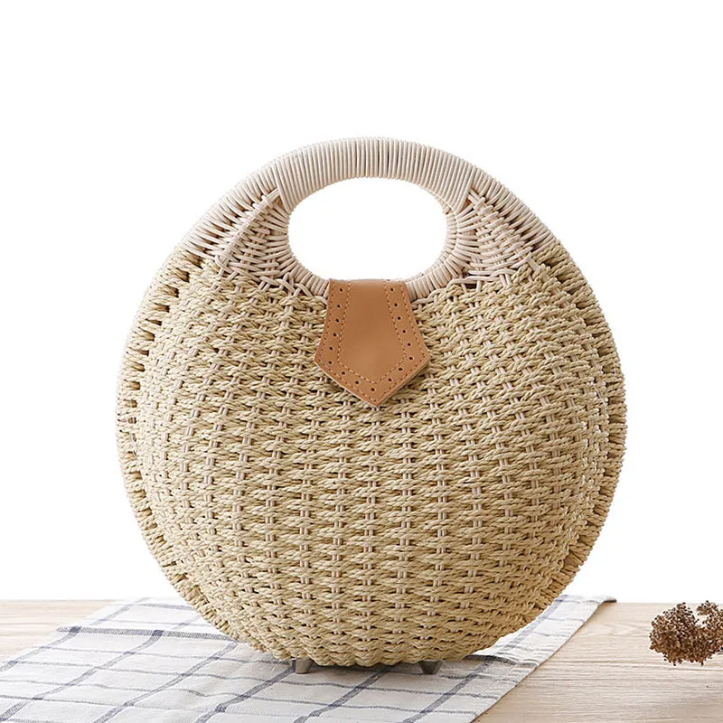 Women's round woven paper rope handbag in beige with hard shell, cover closure, and hard handle