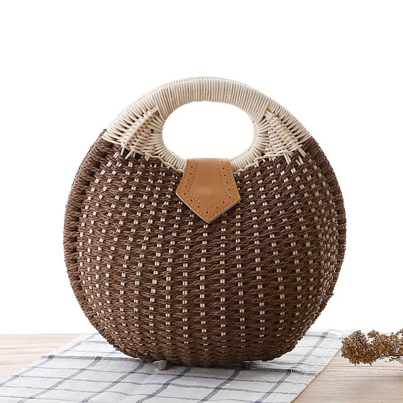 Women's round woven paper rope handbag in beige with hard shell, cover closure, and hard handle