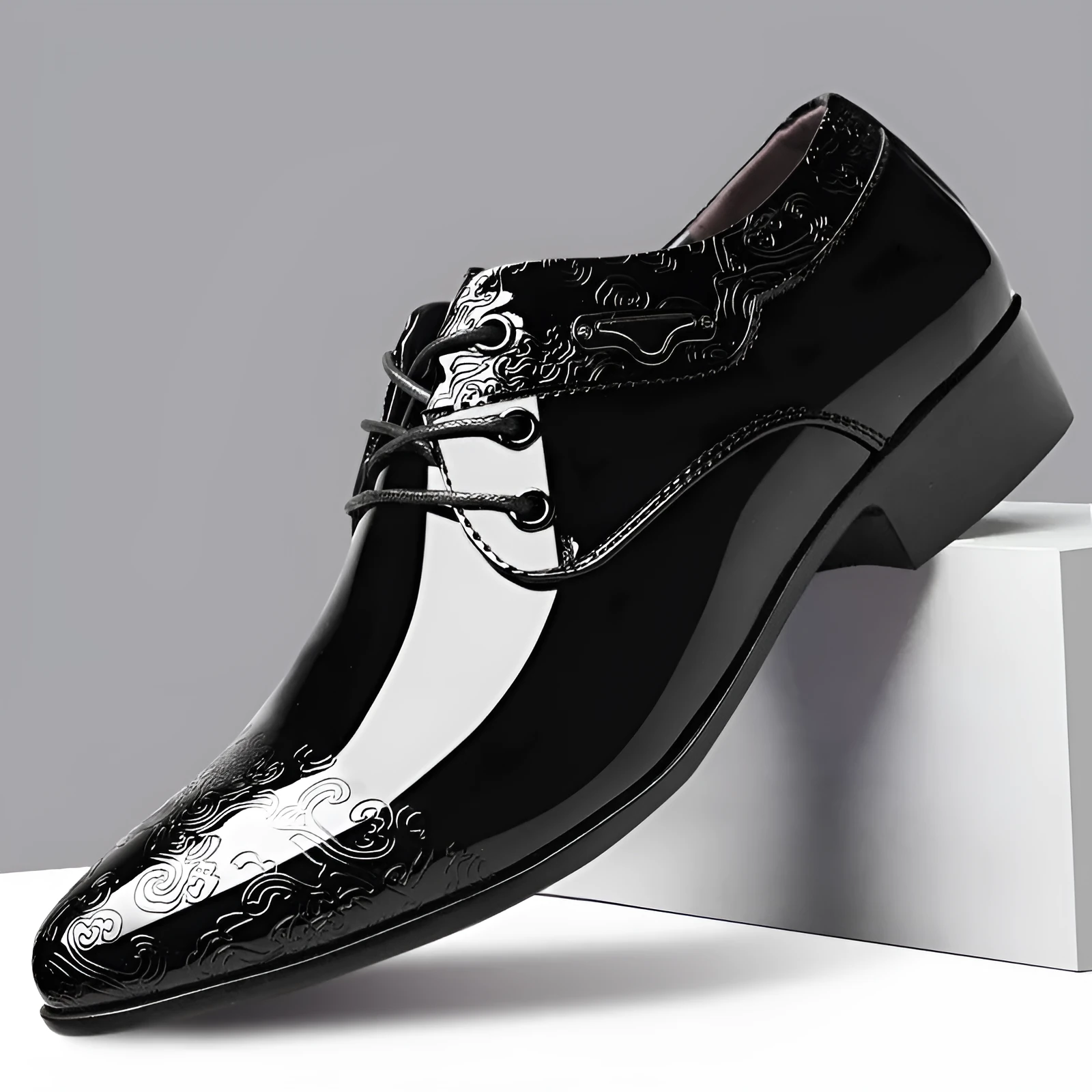 Men's glossy black patent leather formal shoes with pointed toe and carved detail, low top style