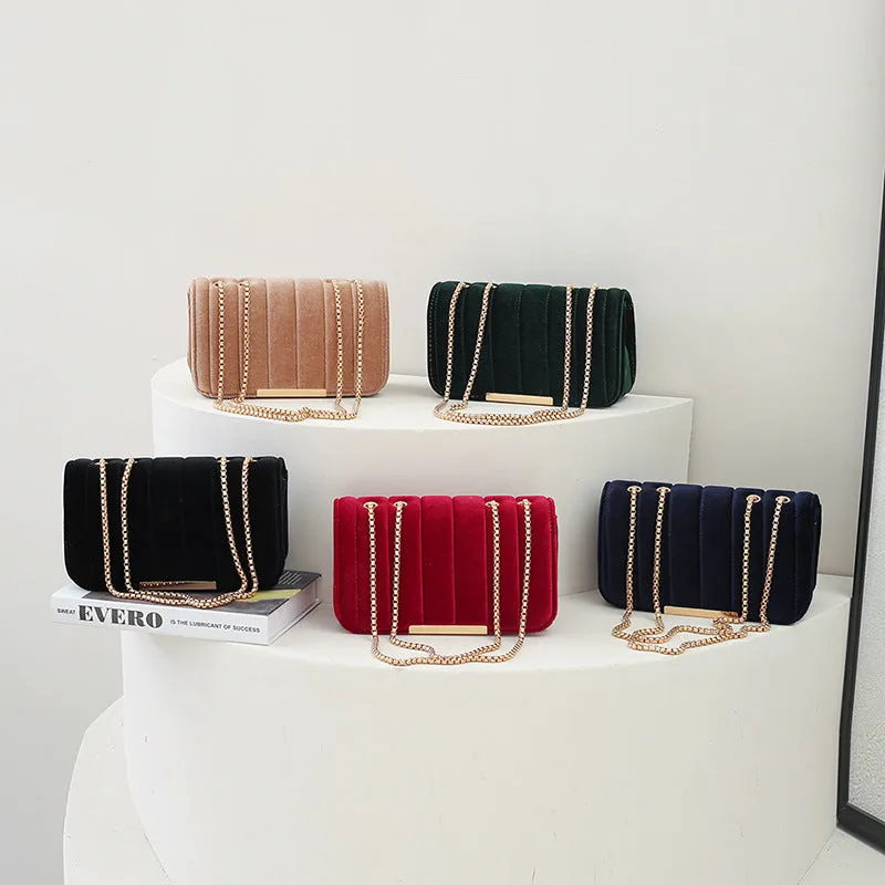 One shoulder velvet chain crossbody bag in solid colour, small square shape with gold chain strap, on white background.