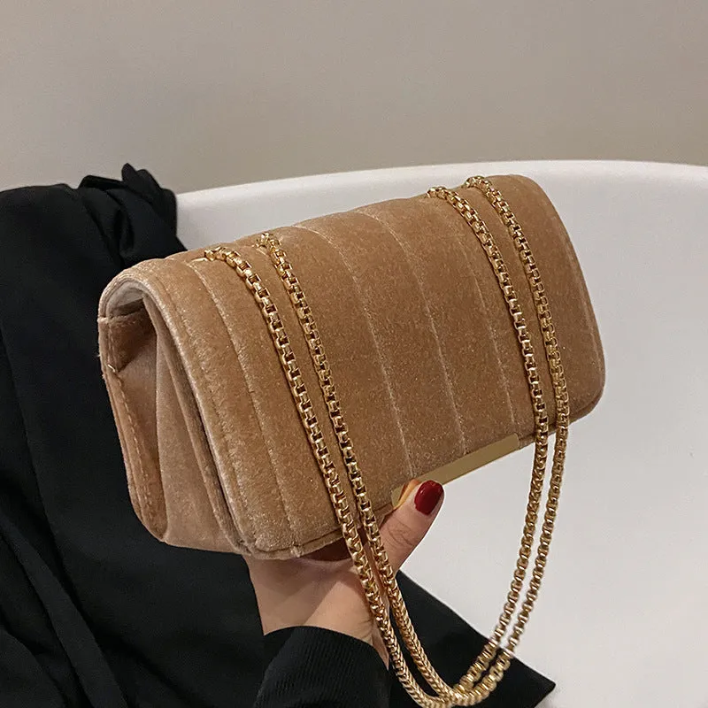 One shoulder velvet chain crossbody bag in solid colour, small square shape with gold chain strap, on white background.
