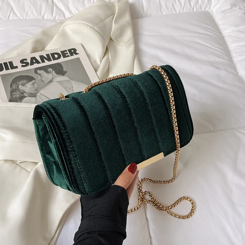 One shoulder velvet chain crossbody bag in solid colour, small square shape with gold chain strap, on white background.