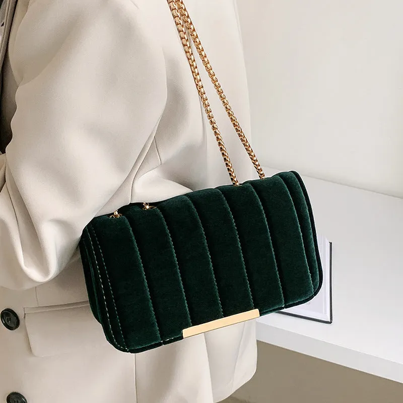 One shoulder velvet chain crossbody bag in solid colour, small square shape with gold chain strap, on white background.