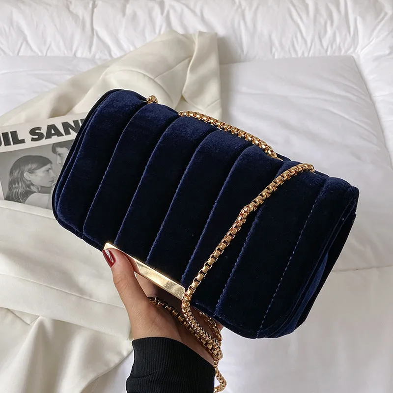 One shoulder velvet chain crossbody bag in solid colour, small square shape with gold chain strap, on white background.