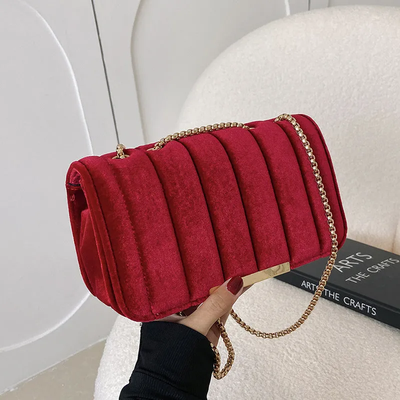 One shoulder velvet chain crossbody bag in solid colour, small square shape with gold chain strap, on white background.