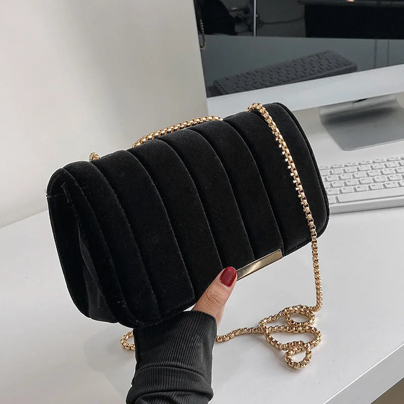One shoulder velvet chain crossbody bag in solid colour, small square shape with gold chain strap, on white background.
