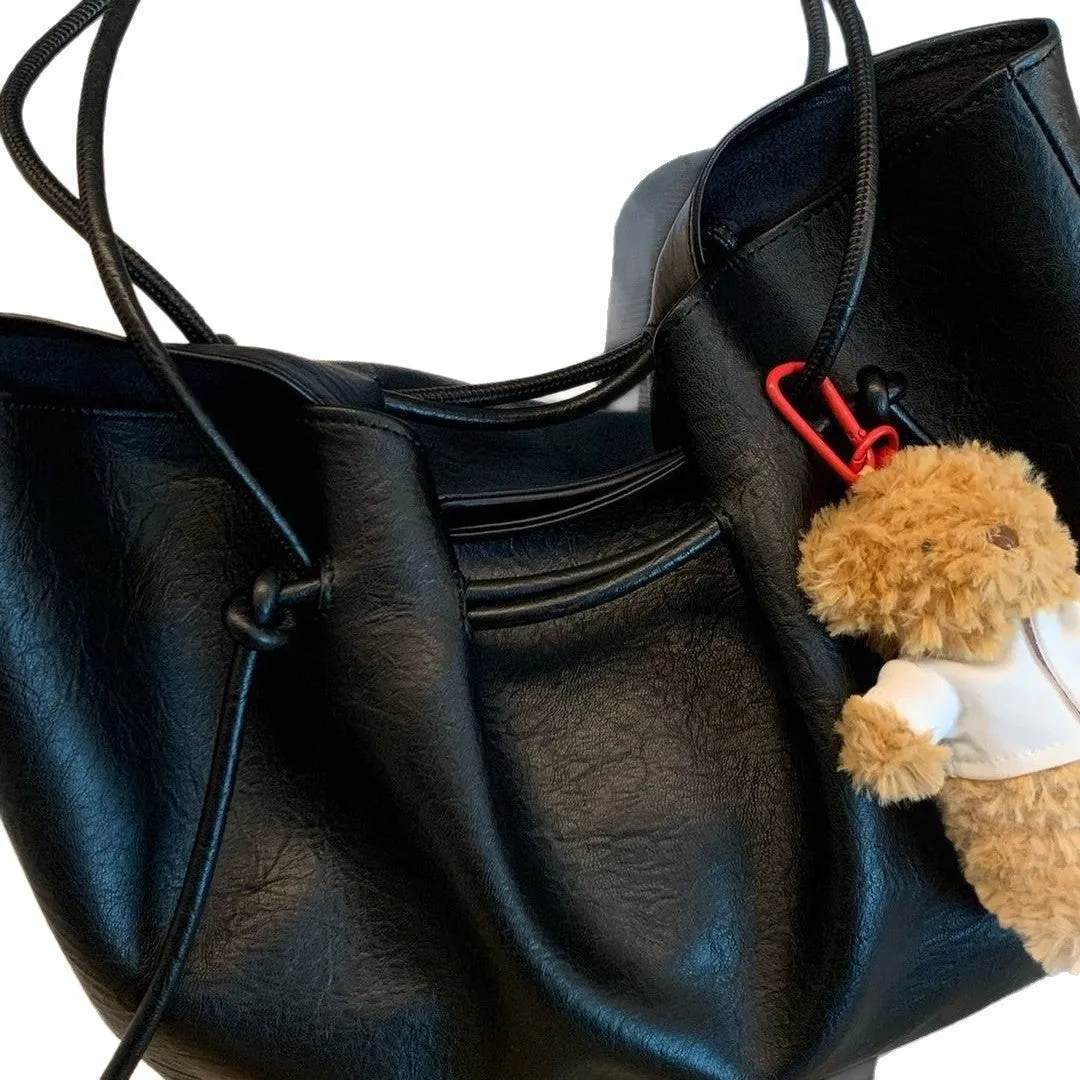 Black PU leather commuter bag with double shoulder straps and solid colour finish, front view
