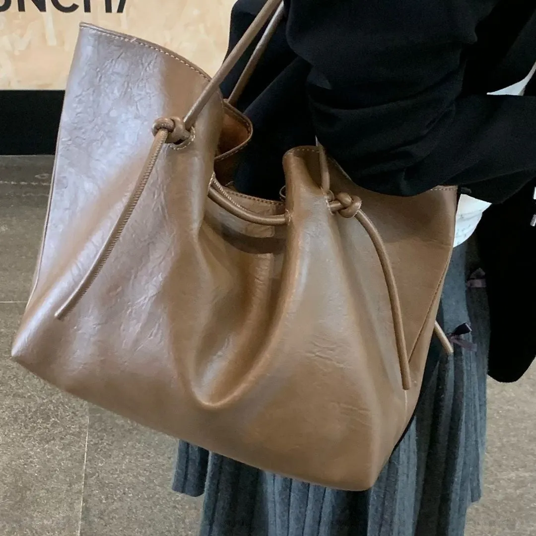 Black PU leather commuter bag with double shoulder straps and solid colour finish, front view