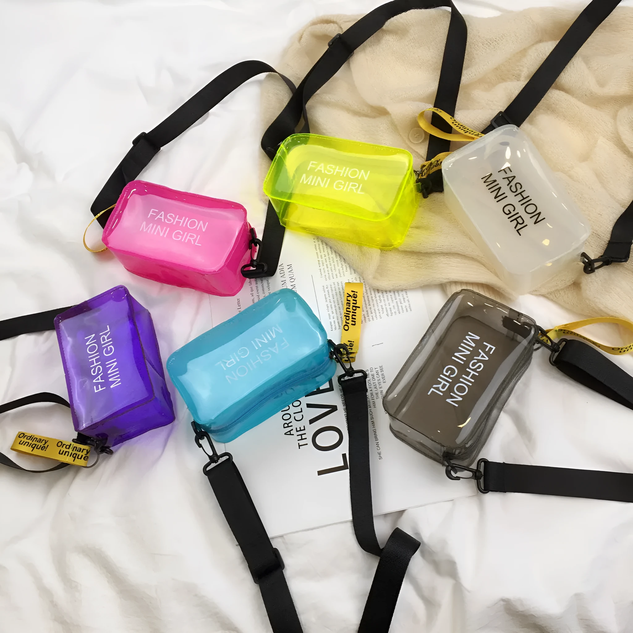 A transparent square jelly cross-body bag in a choice of colours, shown with an adjustable strap and a mobile phone inside.