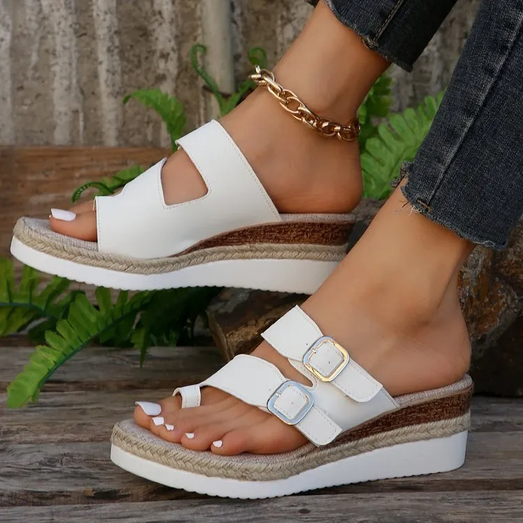 White women's wedge sandals with a woven patent leather upper and peep toe design.