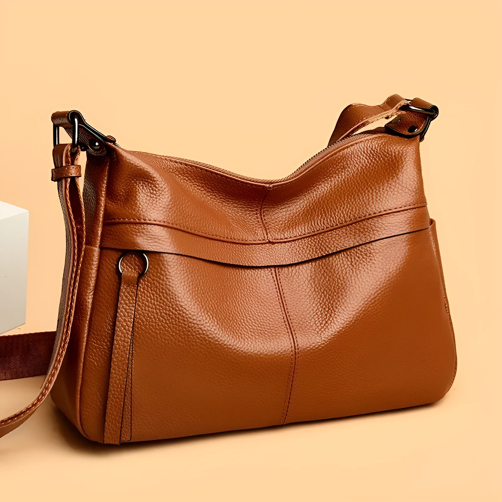 First layer leather one-shoulder crossbody handbag in caramel colour with outer pocket and silver hardware