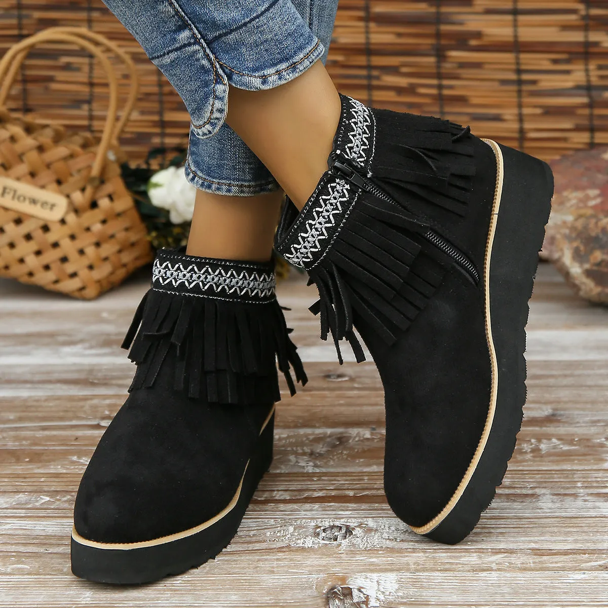 Women's black suede wedge ankle boots with side zipper, tassel detail, and thick rubber sole.