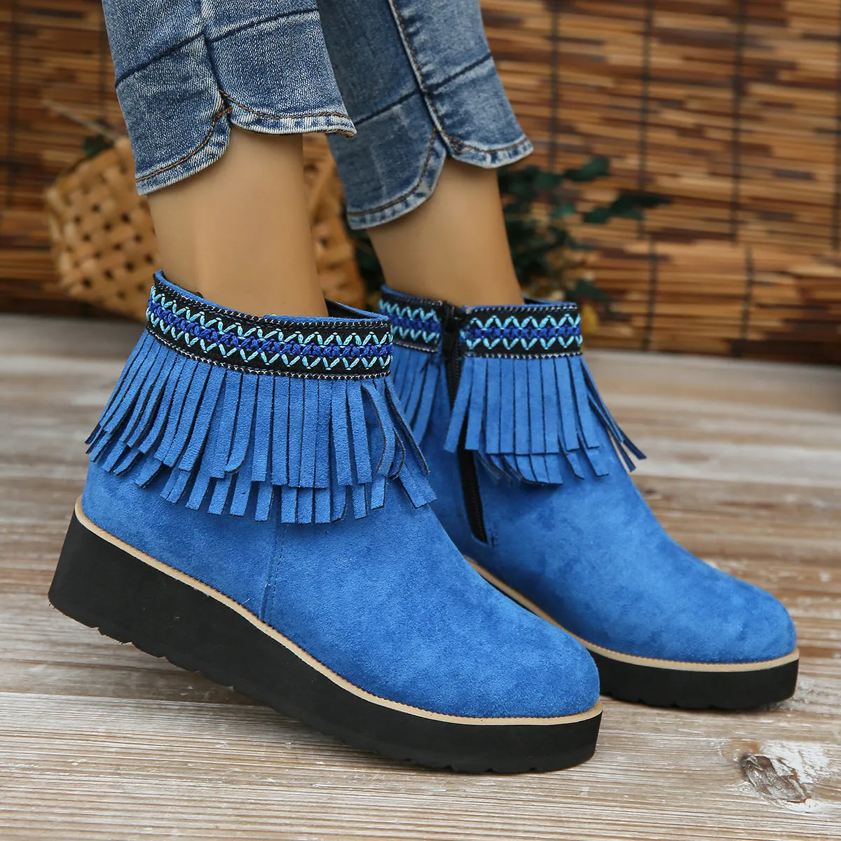 Women's black suede wedge ankle boots with side zipper, tassel detail, and thick rubber sole.