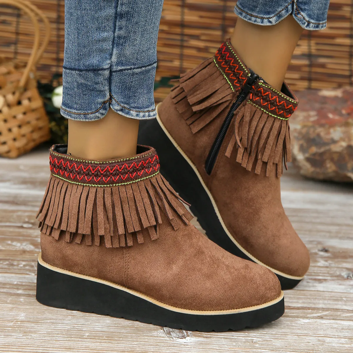 Women's black suede wedge ankle boots with side zipper, tassel detail, and thick rubber sole.