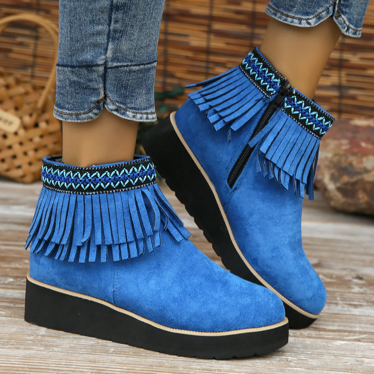 Women's black suede wedge ankle boots with side zipper, tassel detail, and thick rubber sole.