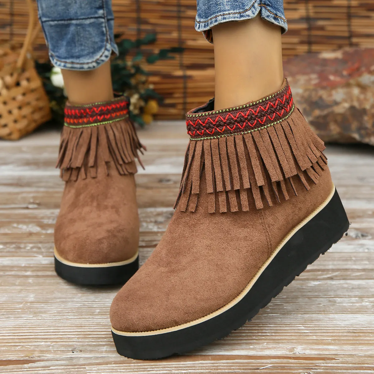 Women's black suede wedge ankle boots with side zipper, tassel detail, and thick rubber sole.