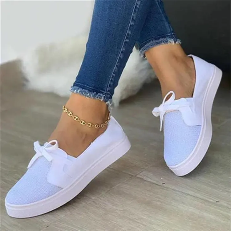 White canvas lace-up flat shoes for women with cross strap design and round toe