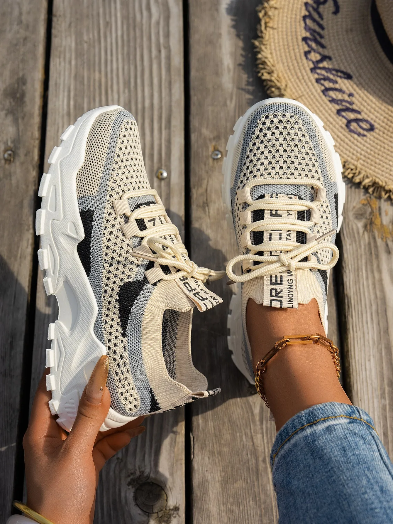 Women's Flyknit mesh lace-up sneakers in a grey colourway with a round toe and flat rubber sole.