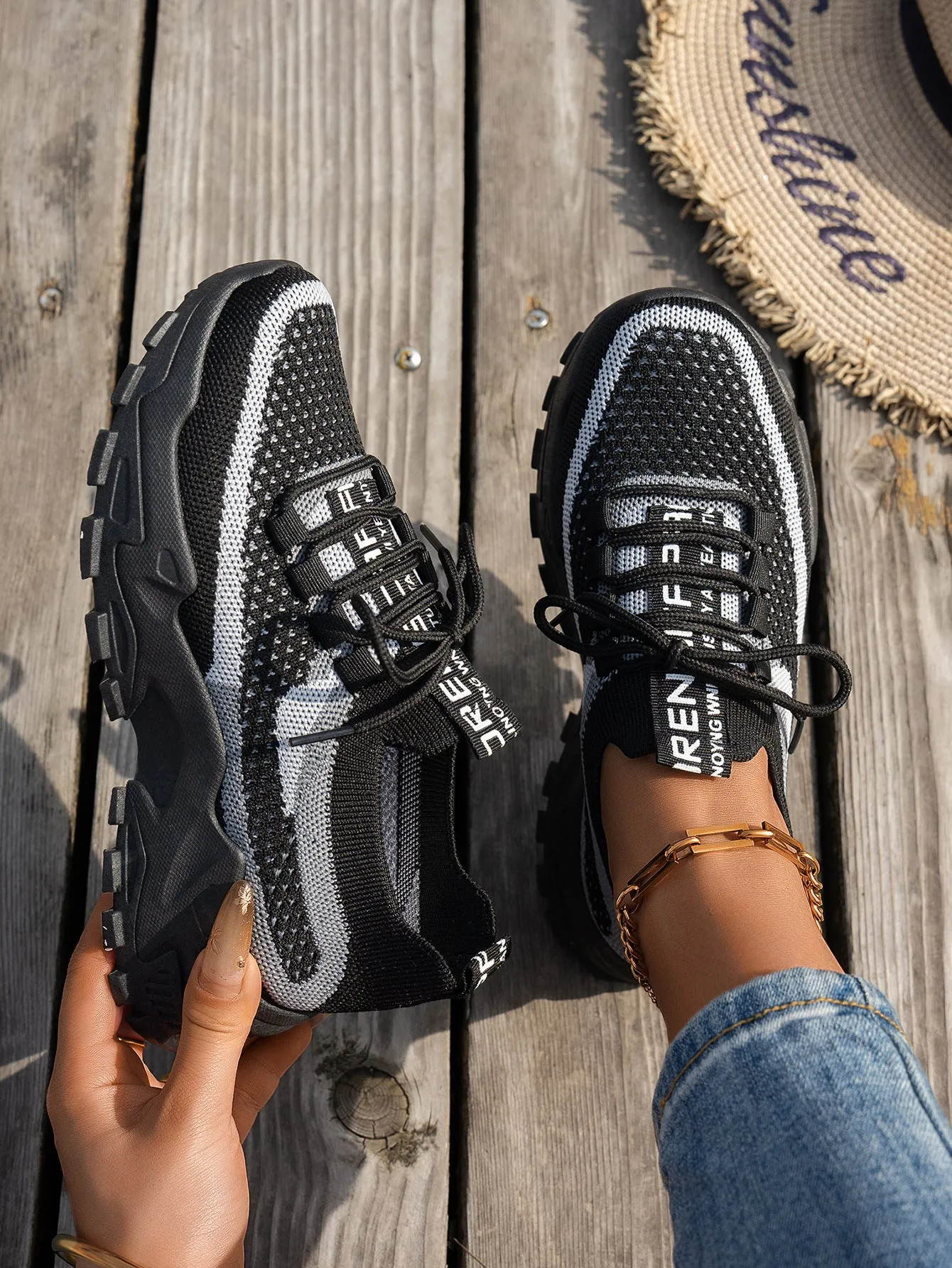 Women's Flyknit mesh lace-up sneakers in a grey colourway with a round toe and flat rubber sole.