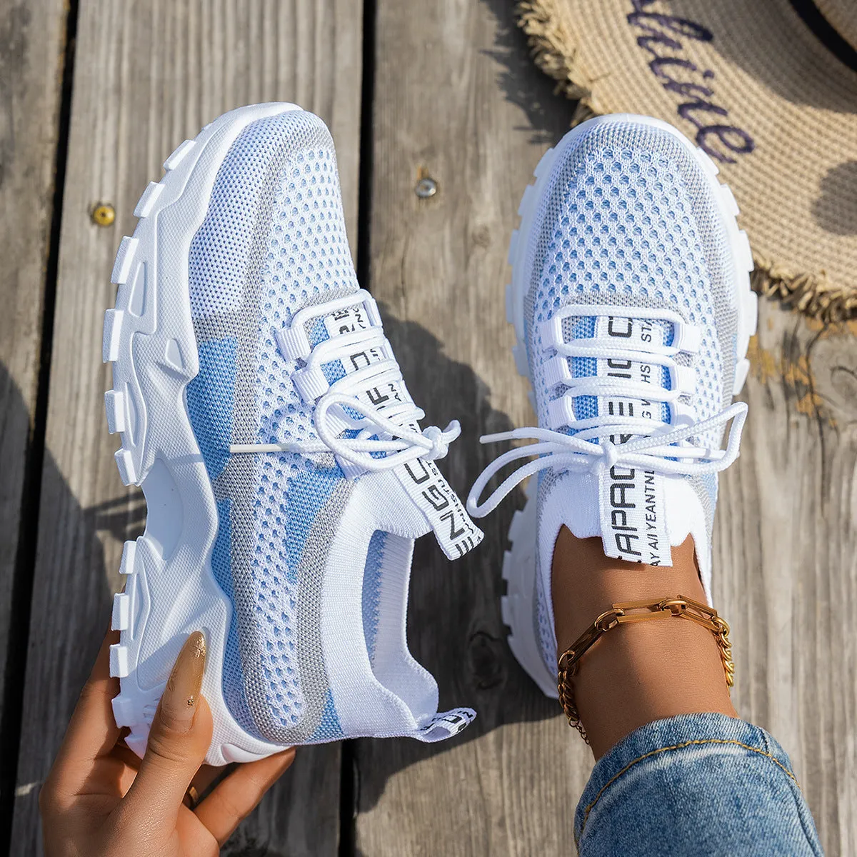 Women's Flyknit mesh lace-up sneakers in a grey colourway with a round toe and flat rubber sole.